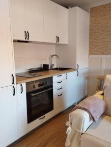 a kitchen with white cabinets and a sink and a stove at MC LAGOS, Bueu in Pontevedra