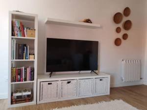a white entertainment center with a flat screen tv at MC LAGOS, Bueu in Pontevedra