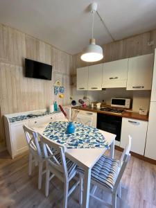 a kitchen with a table and chairs and a kitchen with white cabinets at Da Nonna Puni in Orvieto