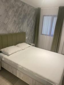 1 dormitorio con 1 cama con sábanas blancas y ventana en Villa Raul, en Costinesti