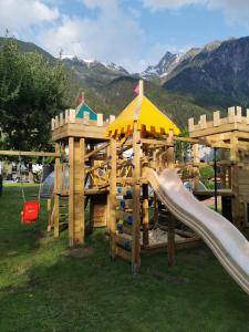 un parque infantil con un tobogán en el césped en Haus Monika, en Oetz