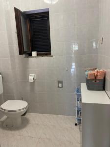 a white bathroom with a toilet and a window at Pag Vlasici in Vlašići