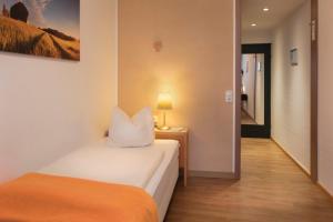ein Schlafzimmer mit 2 Betten und einer Lampe auf einem Tisch in der Unterkunft Heinrich Pesch Hotel in Ludwigshafen am Rhein