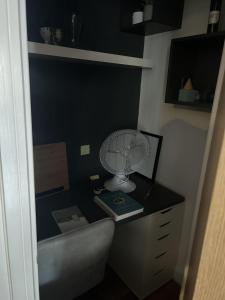 a room with a desk with a fan on it at Immaculate 2-Bed Apartment in Romford in Romford