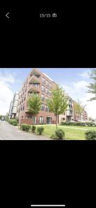 a large brick building with trees in front of it at Immaculate 2-Bed Apartment in Romford in Romford