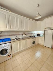 a kitchen with white cabinets and a sink and a dishwasher at CASA BLANCA-Parking gratis in Sanlúcar de Barrameda
