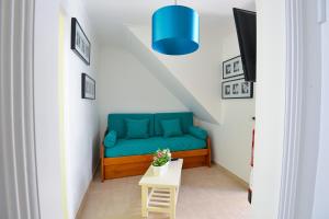 um sofá verde num pequeno quarto com uma mesa em Holidays Nazaré Centro na Nazaré