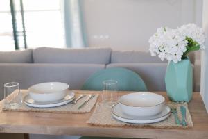a table with two plates and a vase with flowers at Orfhl Studio in Missolonghi