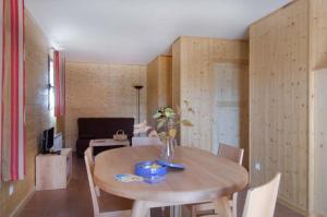 - une salle à manger avec une table et des chaises en bois dans l'établissement Les Châtaigniers du Lac, à Pourcharesses