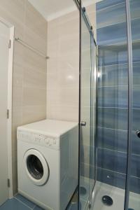 a washing machine in a bathroom with a shower at Holidays Nazaré Centro in Nazaré