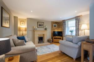 a living room with two couches and a fireplace at Bank House in Chipping Campden