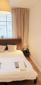 um quarto com uma grande cama branca e uma janela em Klimatyczny apartament z balkonem w samym centrum Wrocławia - W6 em Breslávia