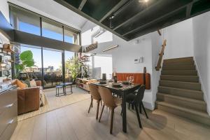 uma cozinha e sala de jantar com mesa e cadeiras em Sol Docklands - Unique 3 Bedroom Loft, Infinity Pool, Gym, Free Parking and Free Trams em Melbourne