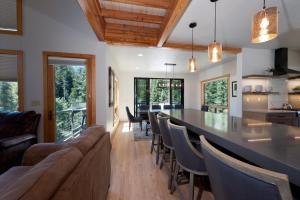 a kitchen and dining room with a long bar and chairs at 1601 Lake Purgatory Drive in Durango