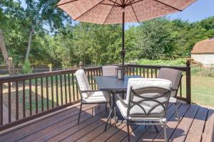 une table et des chaises sur une terrasse avec un parasol dans l'établissement Cozy Norman Home 4 Mi to Oklahoma University!, à Norman