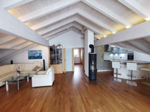 a living room with white furniture and a kitchen at Ferienwohnung Sonnenschein in Rieden am Forggensee