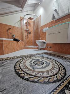 a bathroom with a mosaic tile floor with a shower and a sink at Ferienwohnung Sonnenschein in Rieden am Forggensee