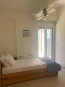 1 dormitorio con 1 cama grande y ventilador de techo en Ageranos seaview house, en Kamáres