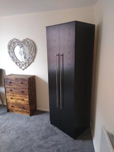 een zwarte koelkast en een houten kist in een kamer bij 124A Castle Street Hinckley in Hinckley