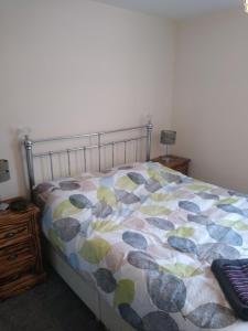 a bedroom with a bed with a comforter on it at 124A Castle Street Hinckley in Hinckley