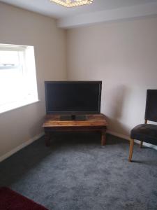 sala de estar con TV de pantalla plana sobre una mesa en 124A Castle Street Hinckley, en Hinckley