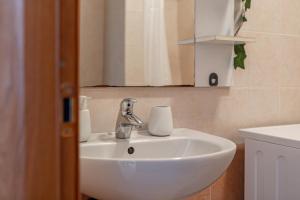 een witte wastafel in een badkamer met een spiegel bij H11 [Bussana 2A] Mare in Bussana Nuova