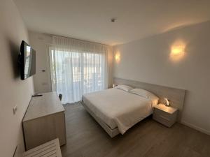 a bedroom with a bed and a tv and a window at Resort le Vele Suites and Apartments in Domaso