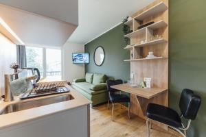 a kitchen and living room with a sink and a couch at Hotel Bloemfontein in Borkum