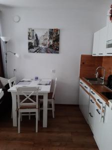 a kitchen with a white table and a sink at Green Ravine in Nałęczów