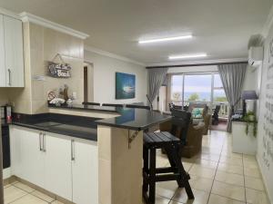 a kitchen with a counter and a table and chairs at 196 Laguna La Crete in Uvongo Beach