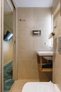a bathroom with a sink and a shower at Hotel Des Remparts Perrache in Lyon