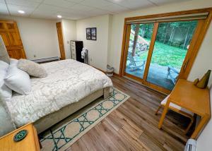 a bedroom with a bed and a sliding glass door at FC54 large mountain cottage with views in Bretton Woods