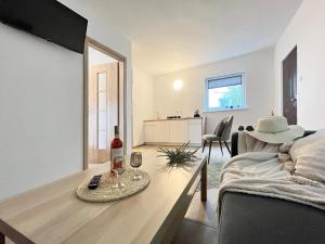 a living room with a table with a bottle of wine at Domek Letniskowy Soluch in Rewal