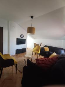 ein Wohnzimmer mit einem Sofa und gelben Stühlen in der Unterkunft Park 2 Branka FREE PARKING in Vranje