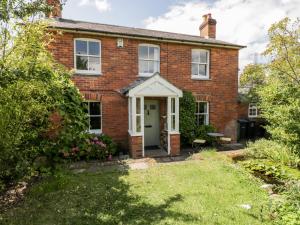 an old brick house with a white door at Fourways in Pewsey