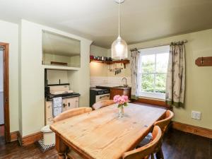 een keuken en eetkamer met een houten tafel bij Fourways in Pewsey