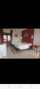 - une chambre avec un grand lit et une table dans l'établissement Casa do Jardim, à Canoa Quebrada