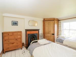 a bedroom with two beds and a fireplace at Fourways in Pewsey