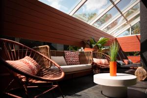 a patio with chairs and a couch in a room with a window at H&ocirc;tel Diana Restaurant & Spa by HappyCulture in Molsheim