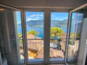 a room with a view of the water from a balcony at Brissaghino al Lago 5* in Brissago