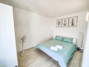 1 dormitorio con 1 cama verde y ventilador en Brissaghino al Lago 5*, en Brissago