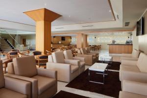 un vestíbulo con sofás, sillas y una mesa en Albufeira Sol Hotel & Spa, en Albufeira