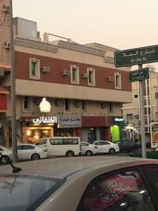 ديم للغرف الفندقية في الخبر: علامة على الشارع مع وقوف السيارات أمام المبنى