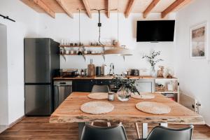 a kitchen with a wooden table and chairs at Czuła Chata Ojców in Prądnik Czajowski +20 photos