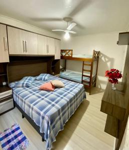 um quarto com uma cama, uma mesa e uma escrivaninha em APTO 14 - ENSEADA, PRÓXIMO REGIÃO DO PÃO DE AÇUCAR no Guarujá