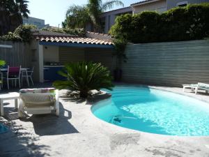 a swimming pool in the backyard of a house at Très bel appartement (40m²) avec piscine privative in Perpignan