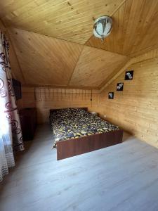 ein Schlafzimmer mit einem Bett in einem Holzzimmer in der Unterkunft Садиба ''Файна Гоффа'' in Werchowyna