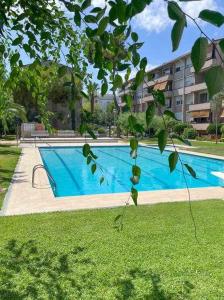 Una gran piscina azul frente a un edificio en Apartment Coloma Piscina y Parking Hostem, en Vilanova i la Geltrú