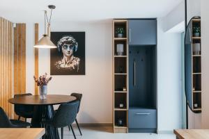 cocina y comedor con mesa y sillas en NOZON Apartments & Wellness, en Odorheiu Secuiesc