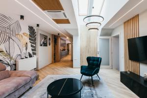 a living room with a couch and a chair at NOZON Apartments & Wellness in Odorheiu Secuiesc